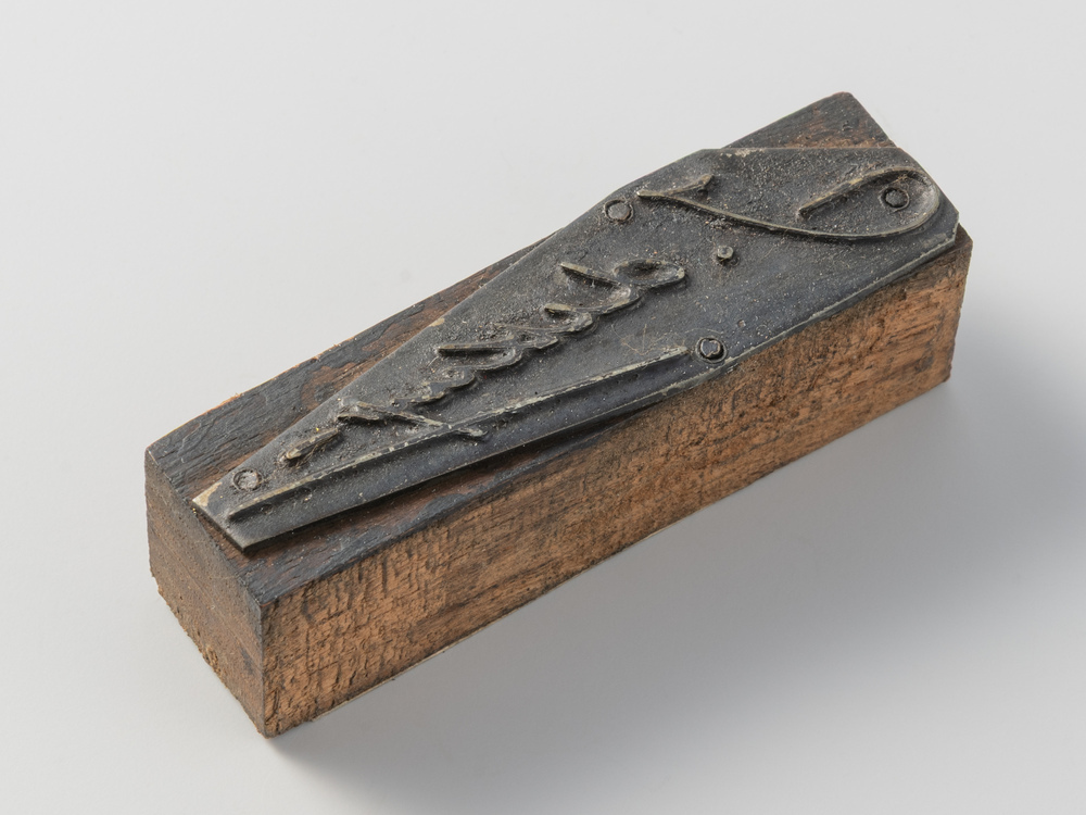 Cliché van zink op een voetje van hout