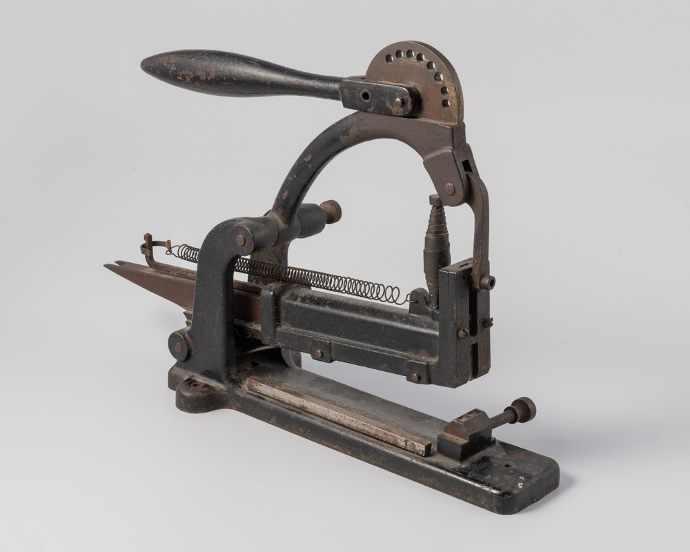 Nietmachine met hefboom op een tafel