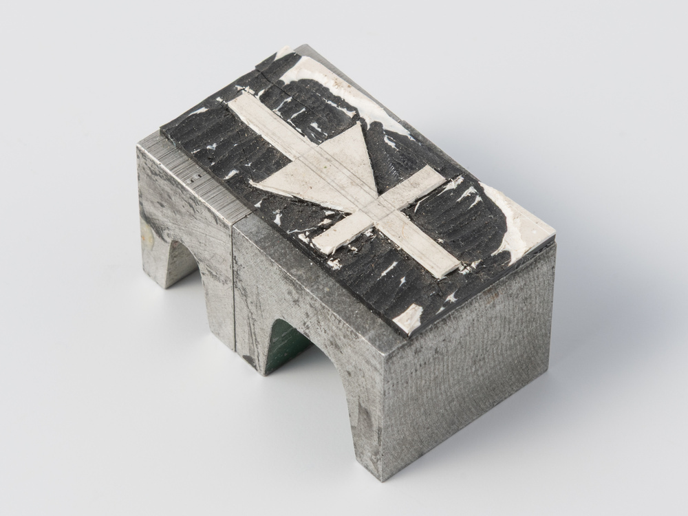 Drukvorm van snijplastic op lood in de vorm van een kruis