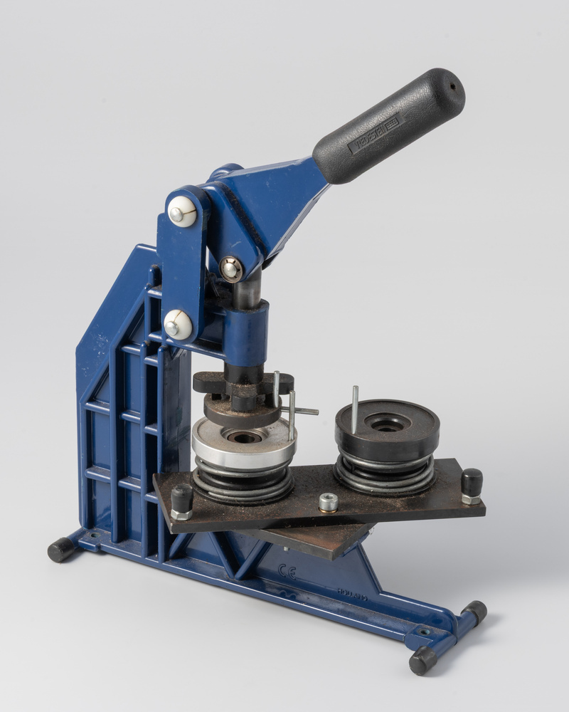 Blauwe buttonmachine