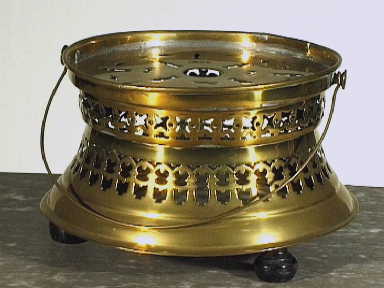 Vuurkomfoor van messing met opengezaagde, naar binnen gebogen, wand.