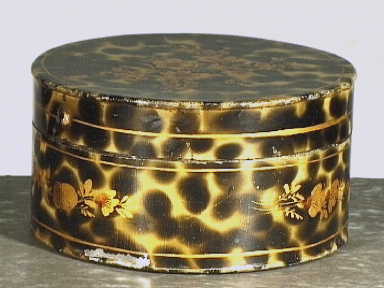 Ronde trommel van blik met schildpaddecor en goudkleurig bloemendecor.