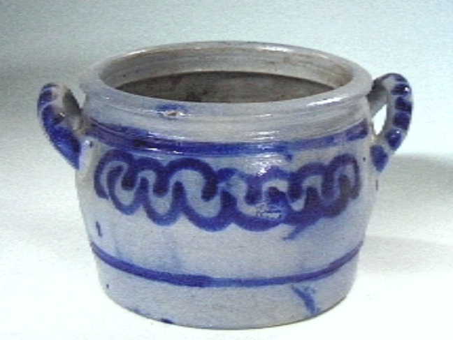 Grijze "Keulse" voorraadpot met blauwe versieringen.