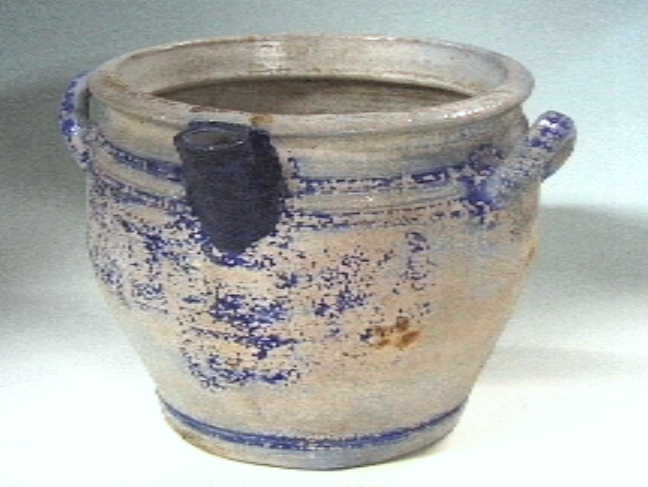 Grijze "Keulse" voorraadpot met blauwe versieringen.