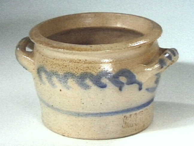 Grijze "Keulse" voorraadpot met blauwe versieringen.