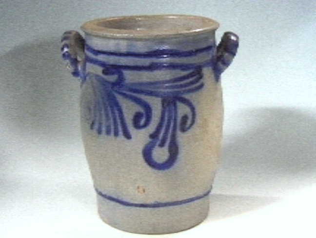 Grijze "Keulse" voorraadpot met blauwe versieringen.