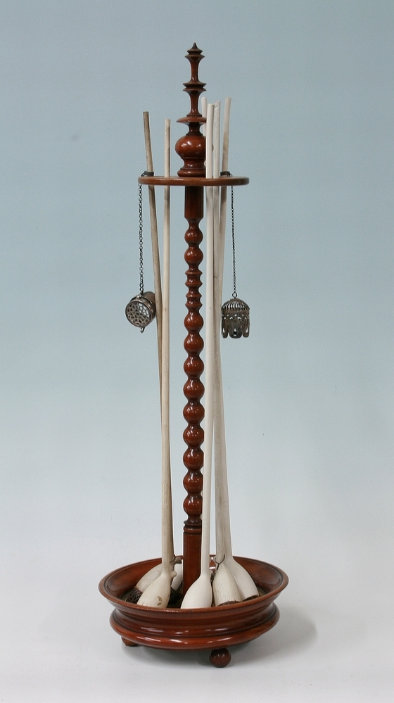 Houten kleipijpenstandaard met zes kleipijpen.