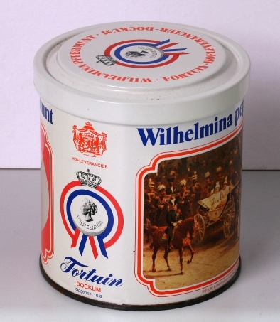 Nieuwe uitgave van een pepermunttrommeltje met draaideksel, warop een busteportret van de jonge Wilhelmina in 1898, en een afbeelding van de intocht in Amsterdam op 5 september 1898.