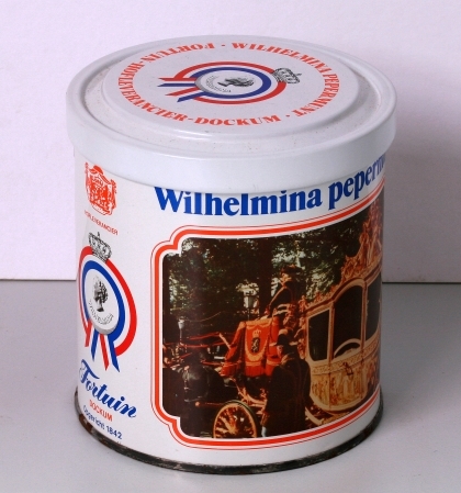 Nieuwe uitgave van een pepermunttrommeltje met draaideksel, warop een busteportret van de jonge Wilhelmina in 1898, en een afbeelding van de intocht in Amsterdam op 5 september 1898.