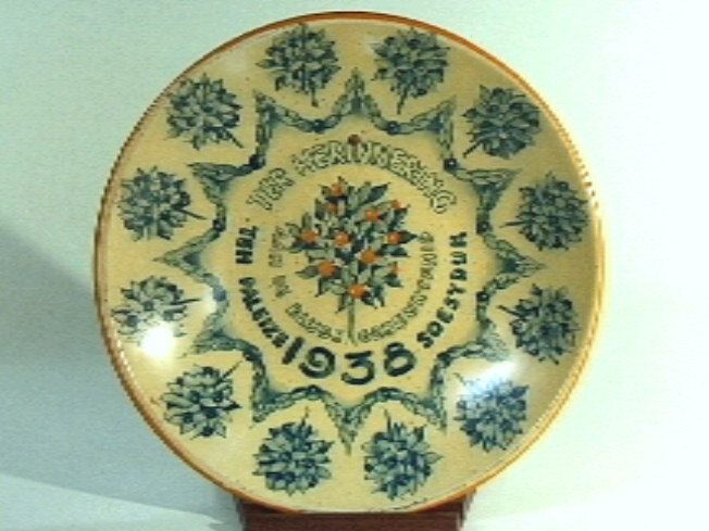 Cremekleurig blikken bord met oranje rand.