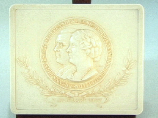 Vierkante plaquette met centraal in een cirkel de busteportretten naar links van Bernard en Juliana.