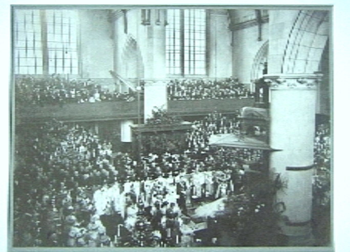 Foto van Huwelijksvoltrekking in de Groote Kerk in Den Haag, het bruidspaar knielend.