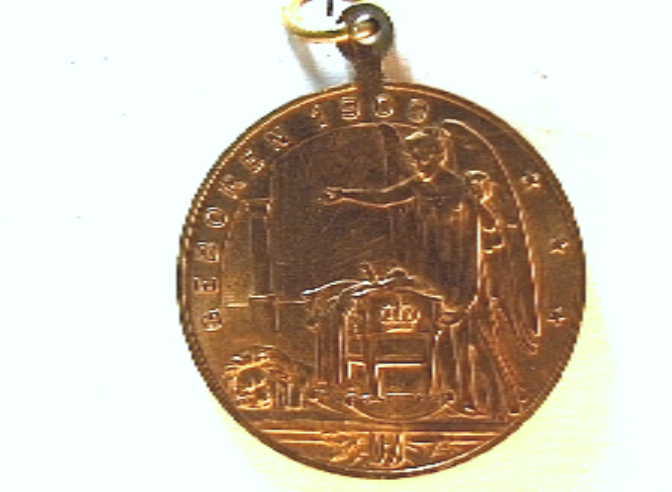 Penning t.g.v. de geboorte van prinses Juliana, met portretkoppen naar links van Hendrik en Wilhelmina, en verso een allegorische figuur bij een wieg. Met oogje en ring.