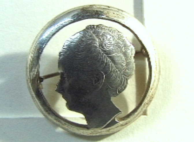 Munt, met uitgezaagd portret van Wilhelmina, verwerkt tot speld. Rijksdaalder, 1940