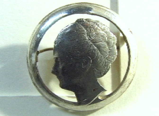 Munt, met uitgezaagd portret van Wilhelmina, verwerkt tot speld.  Rijksdaalder, 1939