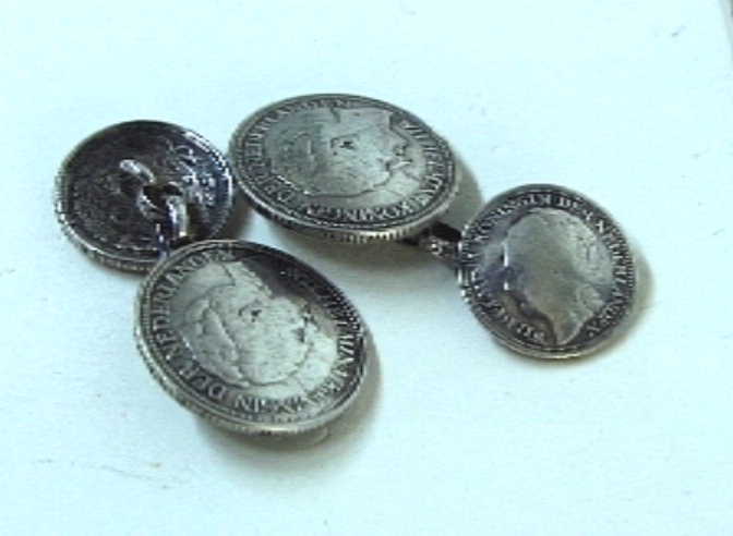 Munten verwerkt tot manchetknopen. Twee stellen van met een kettinkje aan elkaar bevestigd kwartje uit 1941 met een dubbeltje.