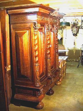 Ranken-kussenkast van notenhoutfineer op eikehout met een rechte kap en drie getorste halve kolommen en veel houtsnijwerk.