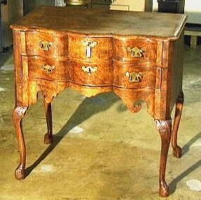 Tafeltje van gepolitoerd wortelnotenfineer op eikehout met twee laden en staat op vier gebogen (Queen Anne) pootjes.