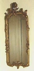 Kleine rechthoekige staande spiegel met een drukbewerkte vergulde lijst.