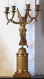 Vergulde kandelaber met vier armen en een gevleugelde vrouw .