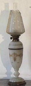 Balustervormige staande petroleumlamp(tafelmodel) met melkglazen voet en schacht.