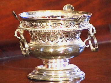 Verzilverd rond theelichtje met monogram BS PH en vier merkjes op de bodem.