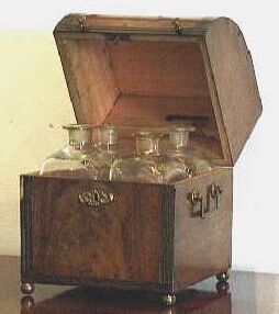 Notenhouten likeurkelder met vier karaffen.