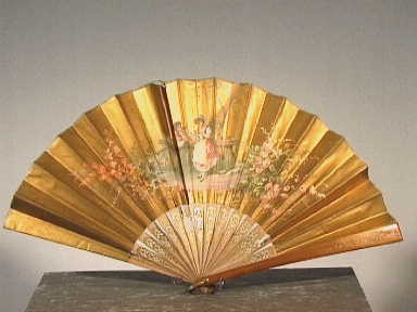 Vouwwaaier met in het midden een voorstelling van een jonge man en vrouw aan weerszijden van een hekje.