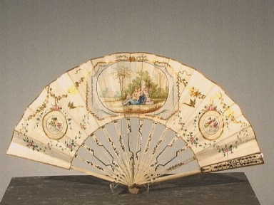 Vouwwaaier met centraal een voorstelling met liefdessymboliek.