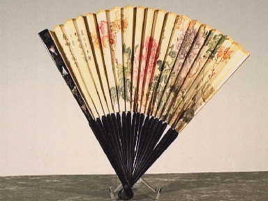 Vouwwaaier met bloemdecoratie en links Chinese (?) lettertekens.