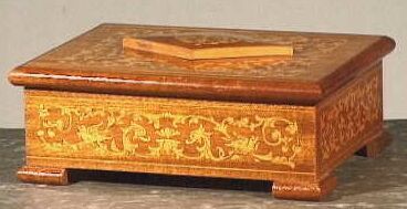 Rechthoekige houten dekseldoos op vier driehoekige voetjes.