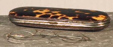 Metalen brillenetui, aan de buitenzijde bekleed met schildpad.