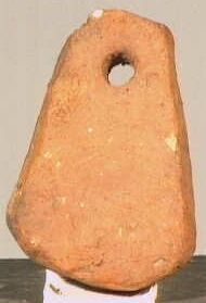 trapeziumvormige rood stenen netverzwaarder (?) met aan bovenzijde een gat.