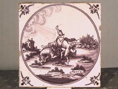 Mangaankleurige tegel met een landschapdecoratie waarin een man van zijn paard valt.