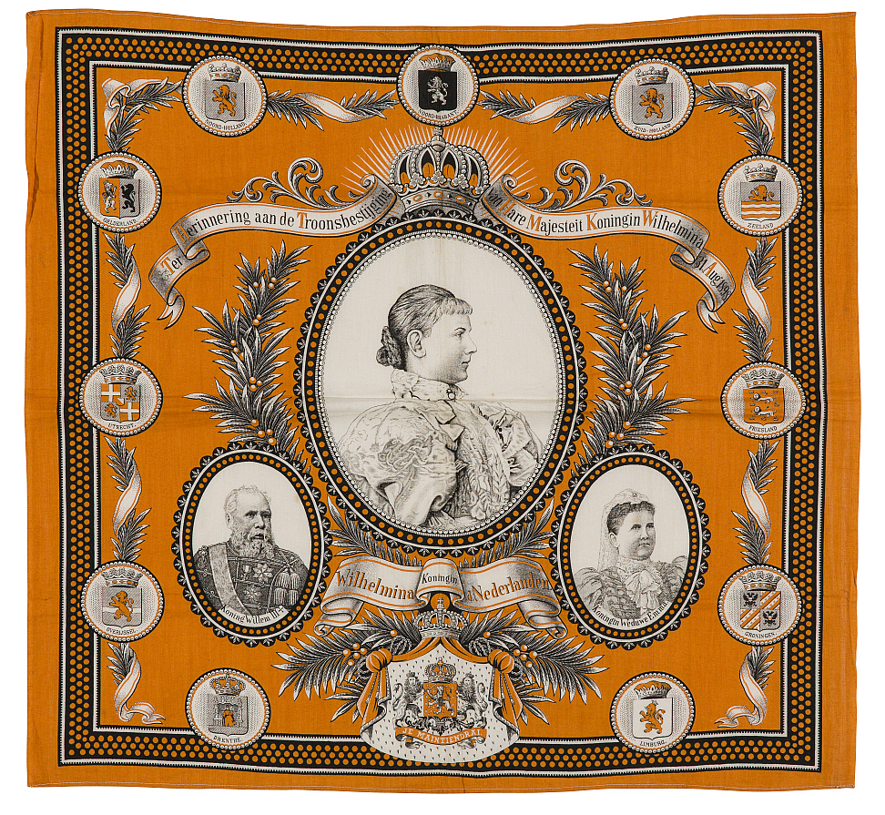 Doek, in de kleuren oranje/zwart/wit, met centraal een medaillon met een busteportret van de jonge Wilhelmina.
