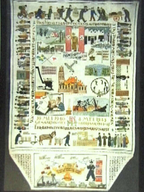 Reproductie van een kleurig geborduurd wandkleed, met herinneringen aan de bezettingstijd.