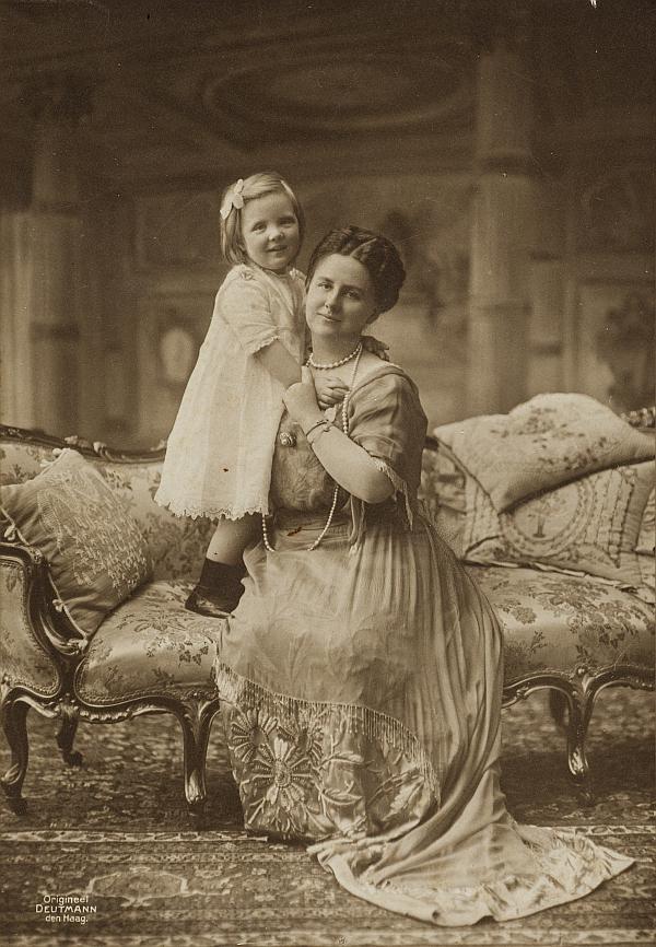 Foto van Koningin Wilhelmina met de driejarige prinses Juliana  poserend voor het Eetzaaldecor in het fotoatelier in Paleis Het Loo.