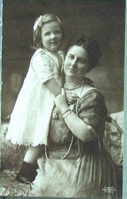 Foto van Wilhelmina zittend op een sofa met Juliana staande naast haar.