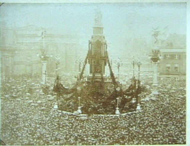 Versierd monument op De Dam in Amsterdam met mensenmenigte eromheen, t.g.v. huwelijk Wilhelmina en Hendrik in 1901.