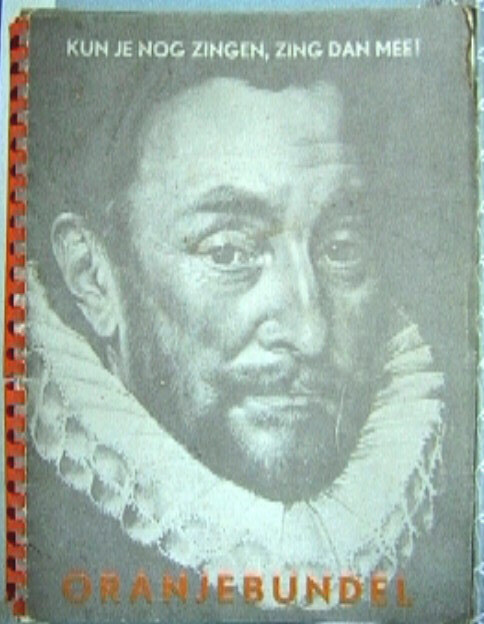 Zangbundel uit de periode van Wilhelmina met oranje kunststof ringband.