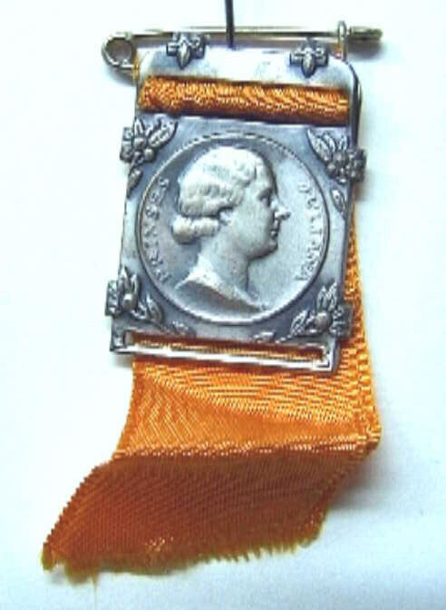 Rechthoekige gesp met speld met in cirkel een portret naar rechts van prinses Juliana.
