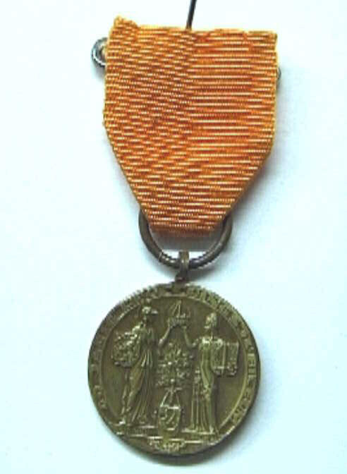 Penning met oranje lintje en speld, met busteportret naar rechts van koningin Wilhelmina.