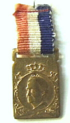 Rechthoekig insigne met in een cirkel een portret van koningin Wilhelmina naar links. Met rood-wit-blauw lintje.