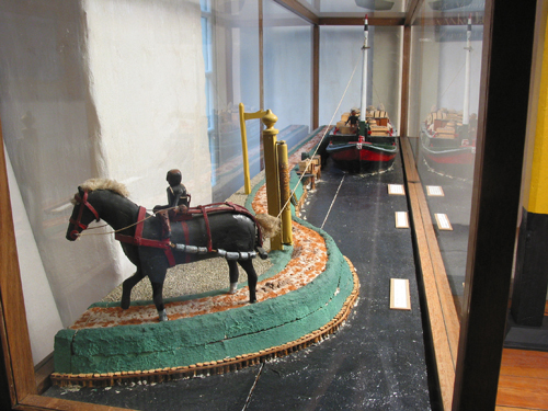 Maquette van een trekschuit, type snik, met rolpaal trekpaard en scheepsjager, zoals in gebruik rond 1900, vervaardigd door de heer H. Kraan uit Nieuwe Pekela, 1e helft 20e eeuw.