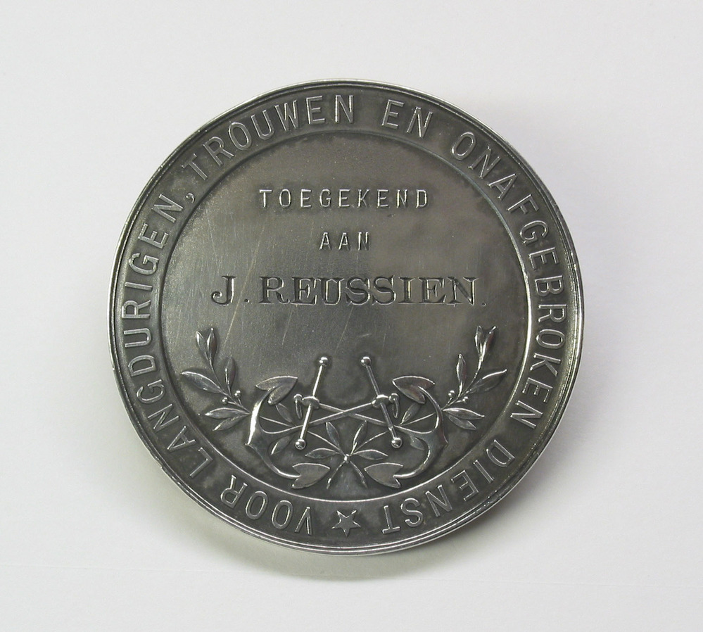 Erepenning toegekend aan kapitein J.Reussien wegens 25 jaar trouwe dienst, door de Vereniging tot Behartiging der Stoomvaartbelangen in Nederland namens de Drentsche Stoomboot Maatschappij, 1910