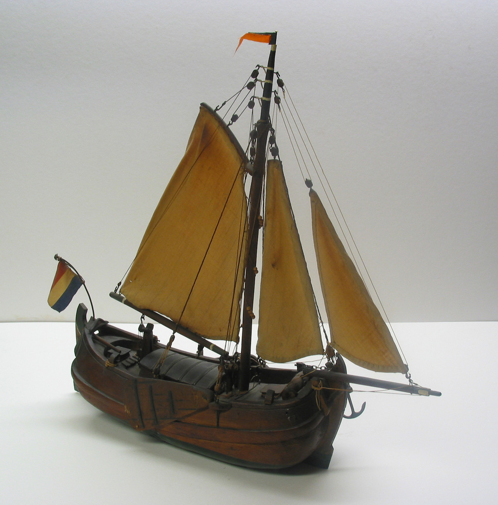 Houten volmodel van een poon met statie, voorzien van een grootzeil, fok en kluiver. Met ronde luikenkap.