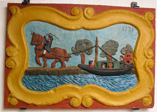 Replica van een gevelsteen uit 1771 met een trekschuit en scheepsjager op trekpaard, voorheen in café De Oude Snikstal op de hoek Rodeweg/Korreweg
