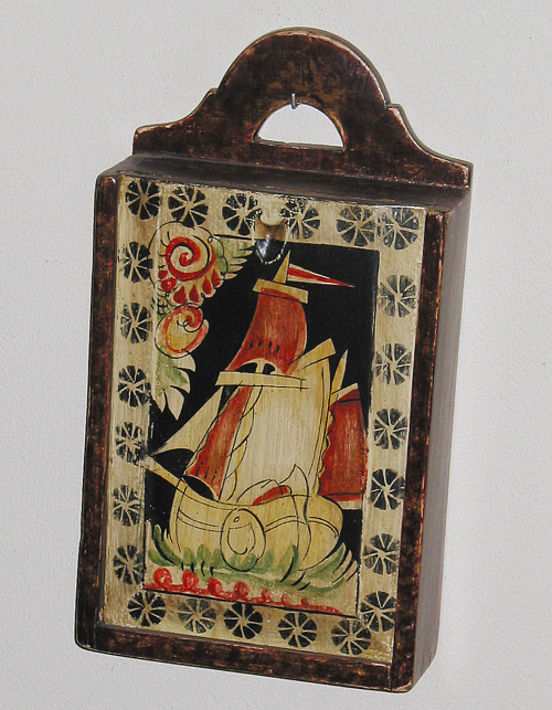 Beschilderde houten schooltas met op het schuifdeksel een scheepsafbeelding.