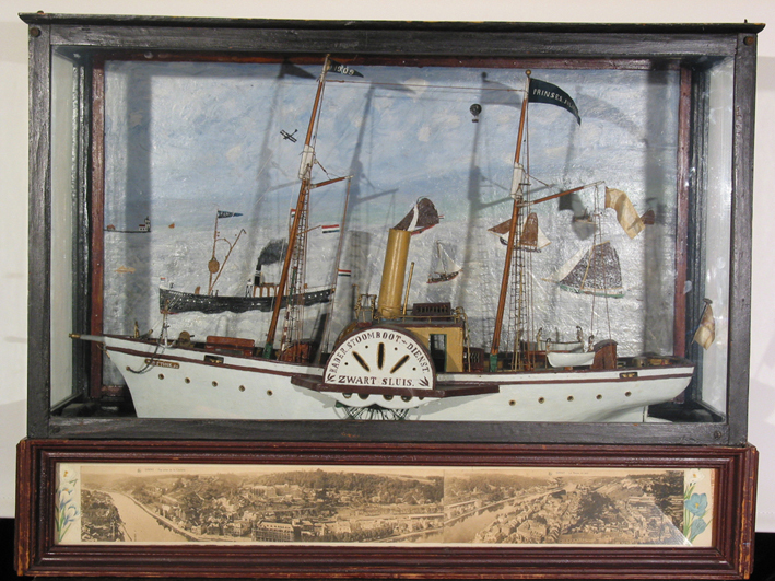 Volkskunstig model van een raderstoomboot in vitrine T. Ottink Jz, 1909