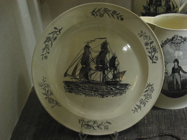 Schotel met afbeelding van een driemastschip met Engelse vlag. Engels creamware aardewerk, 18e eeuw.